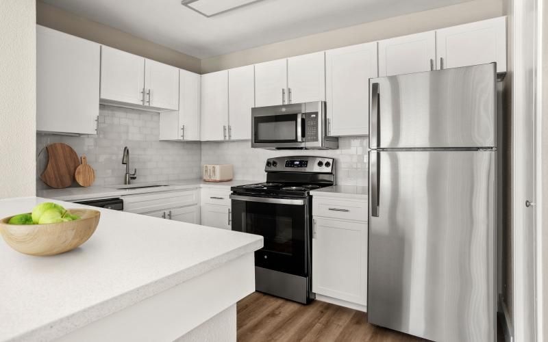 a kitchen with white cabinets and stainless steel appliances