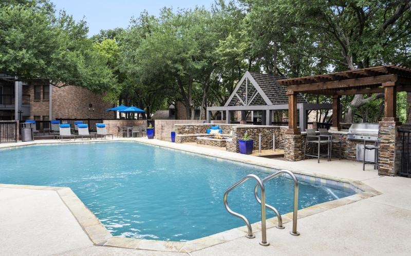 a swimming pool with outdoor kitchen, grilling area