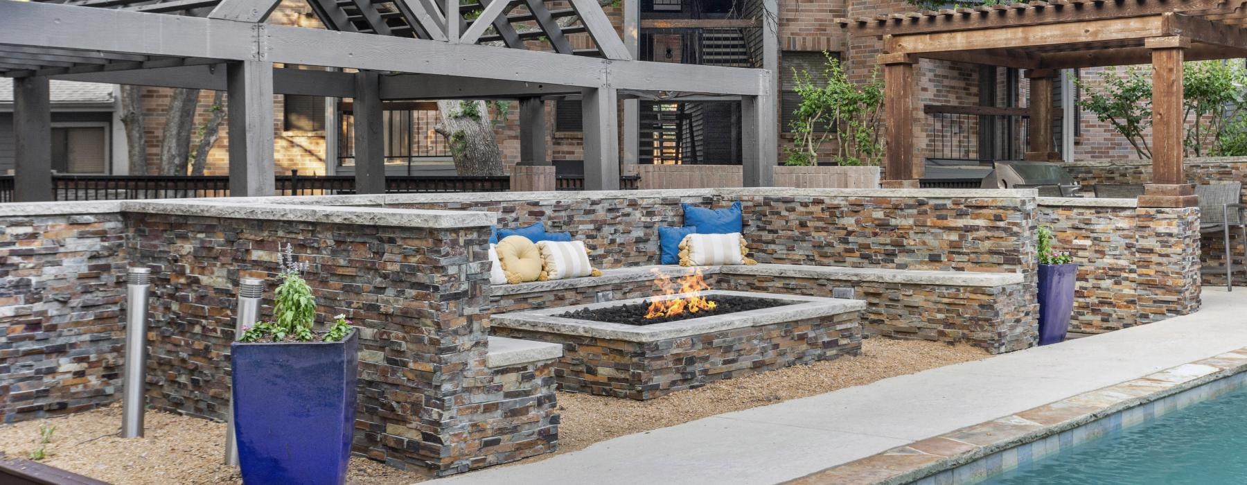 fire pit seating area beside a clubhouse pool 